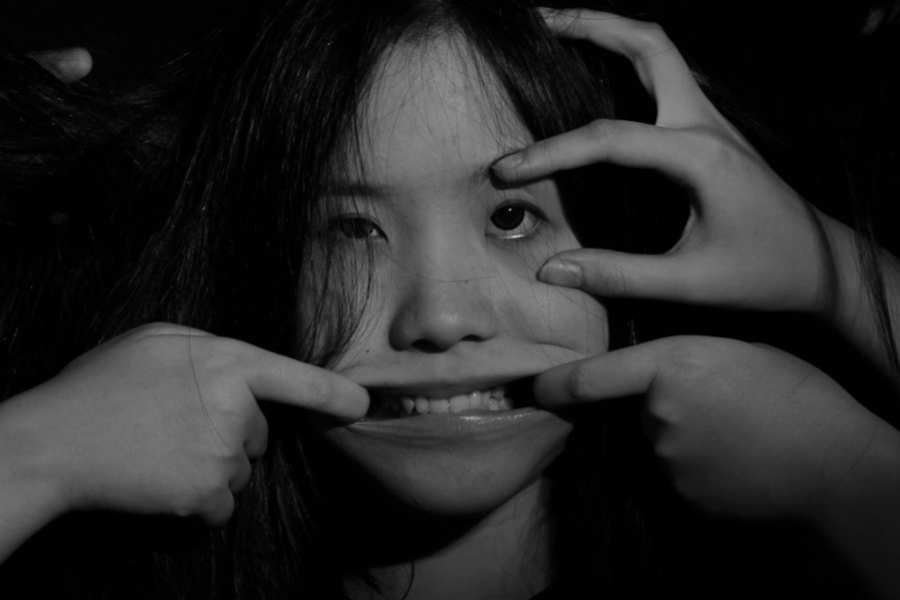 beauty standards: fingers pulling a woman's face in multiple directions, symbolizing beauty standards.